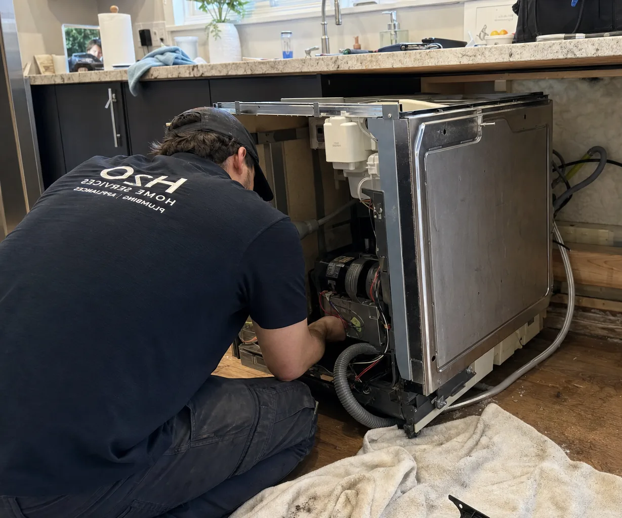 Technician servicing a built-in dishwasher up close